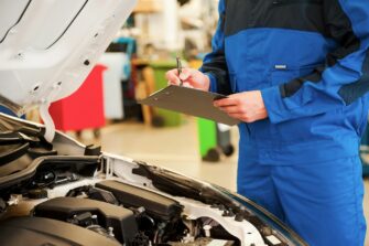 close-up-of-man-in-uniform-examining-car-and-writing-something